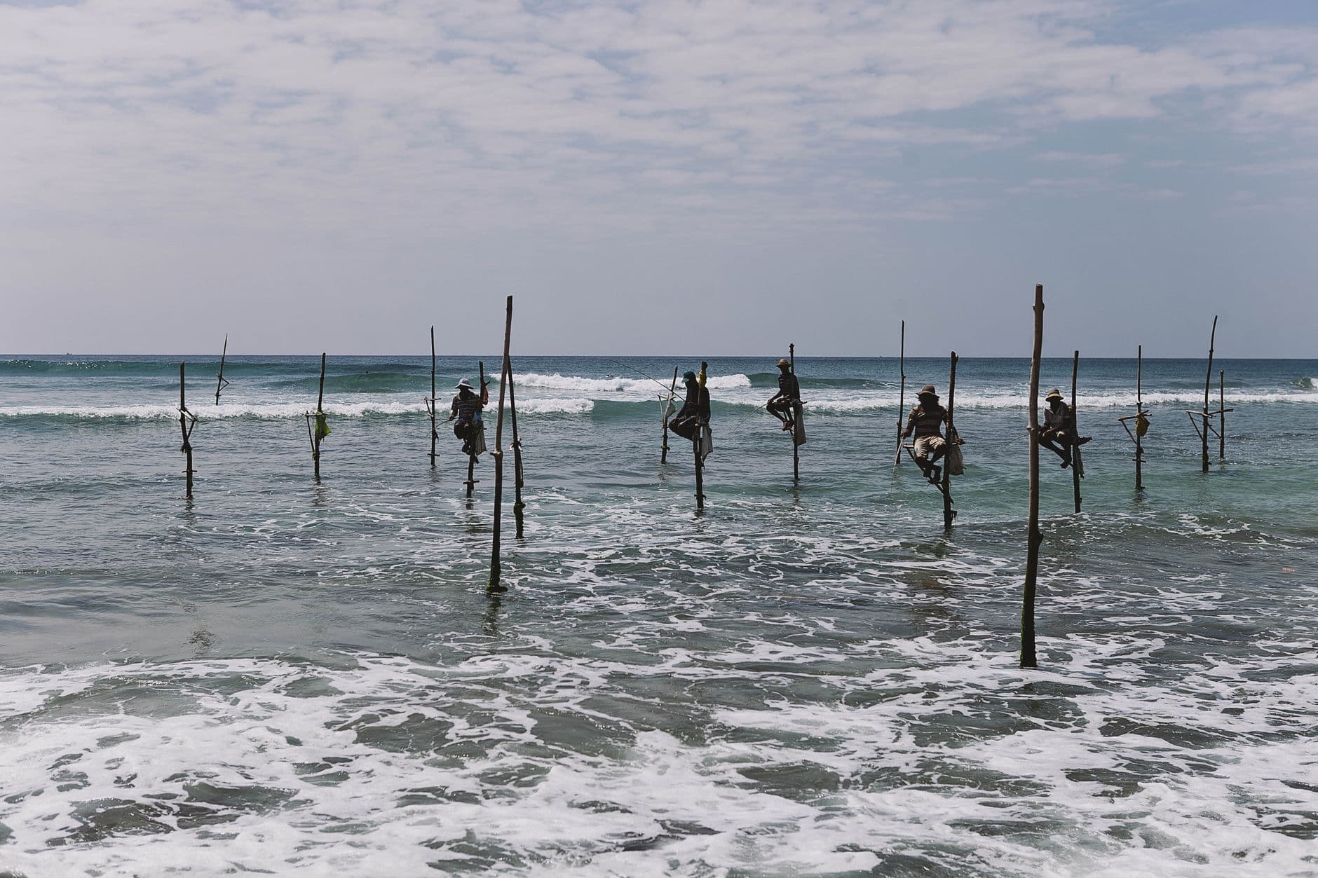 Stilt fishermen perched over the reef near Ahangama