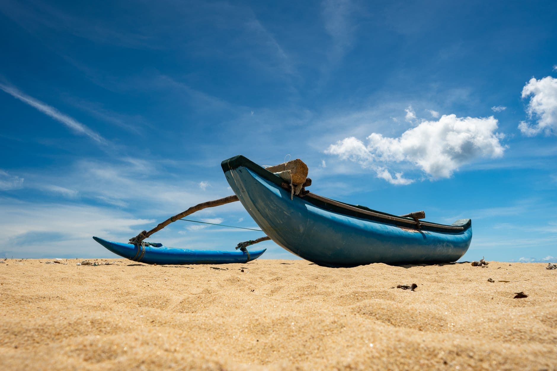 An outrigger catamaran resting on the east-coast sand