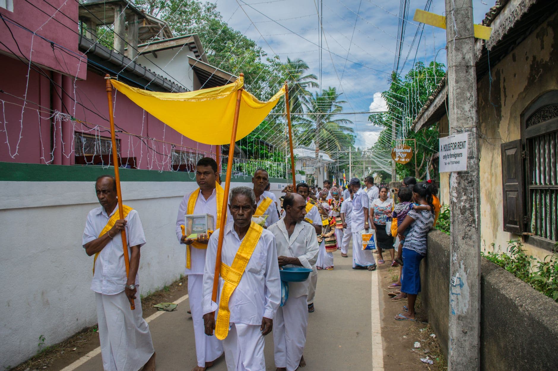 White-clad devotees carrying offerings in a temple procession
